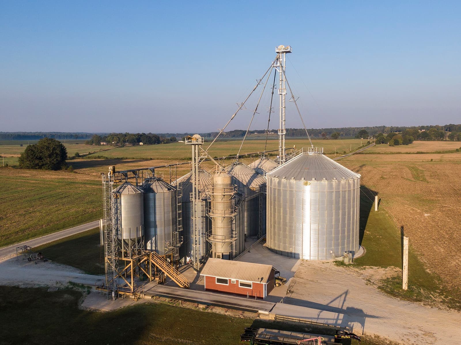 Grain bins and a grain leg beside fields on a Tennessee farm